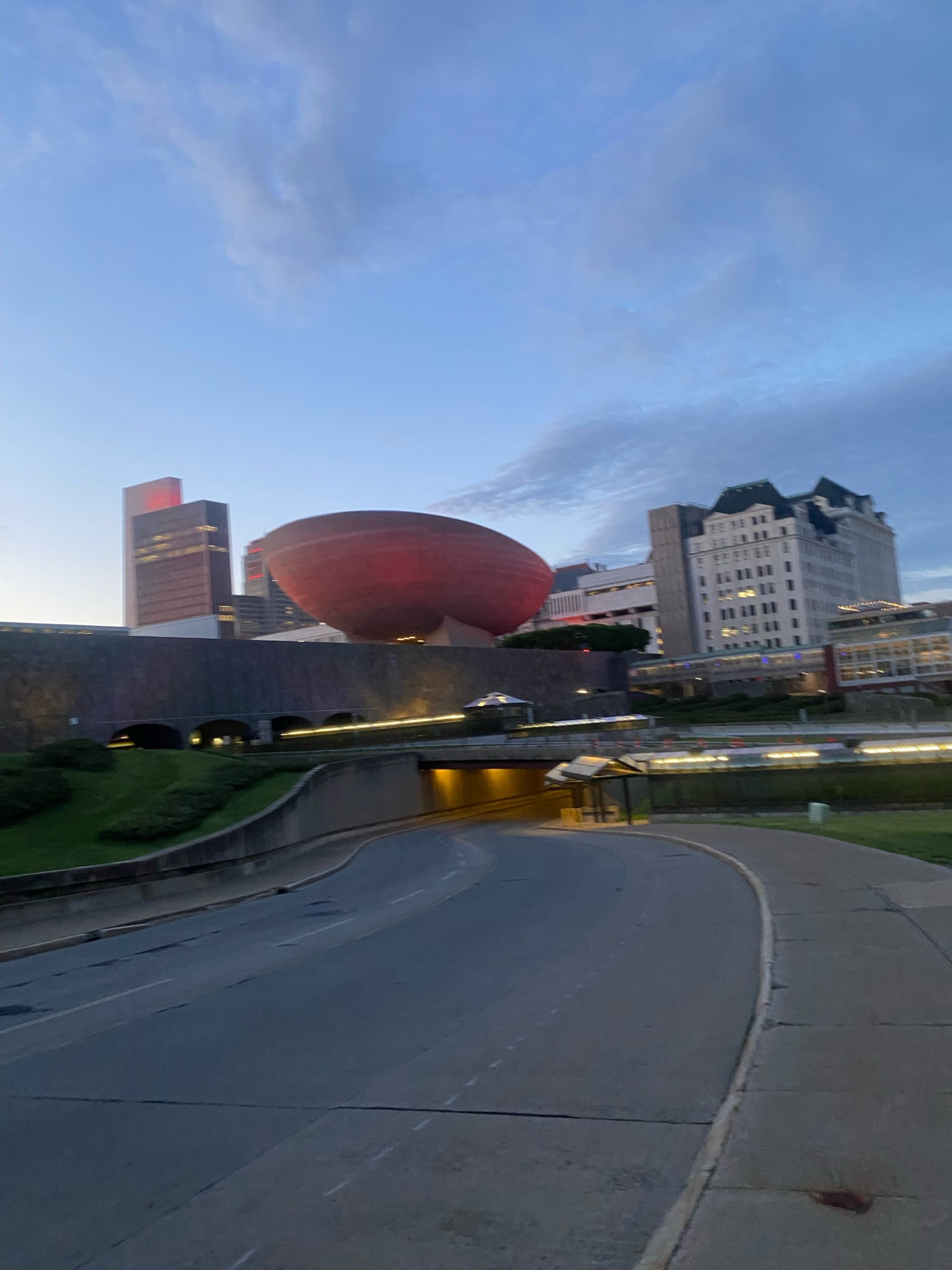 Brutalist curved theatre against a dusk sky