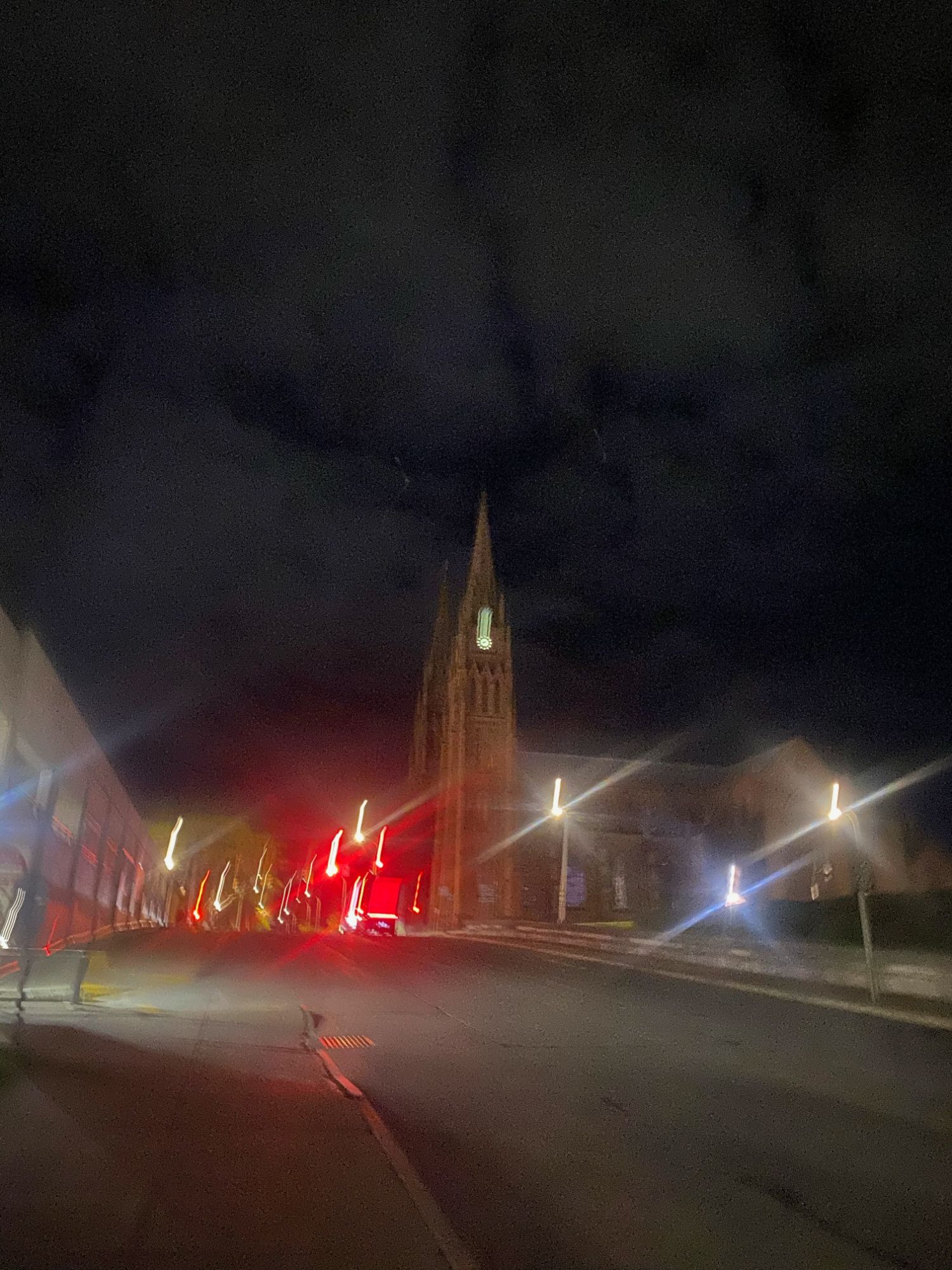 Gothic cathedral spire at night with streaked street lights